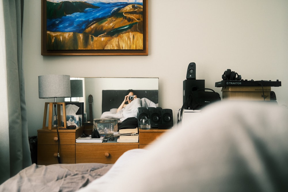 a bedroom with a dresser and a painting on the wall