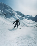 a man riding a snowboard down a snow covered slope