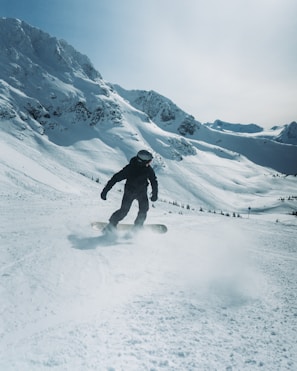 a man riding a snowboard down a snow covered slope
