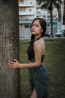 photography poses for women,how to photograph a woman leaning against a tree in a park