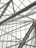 Complex geometric metal framework with intersecting beams visible through a transparent ceiling, likely part of an architectural structure.