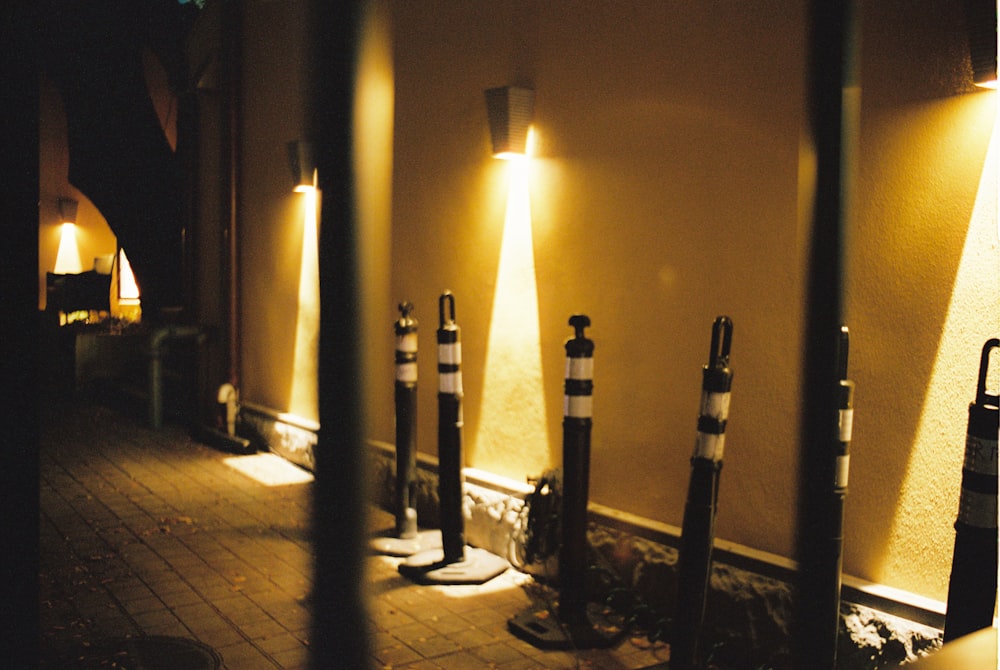 a row of street lights sitting next to a wall