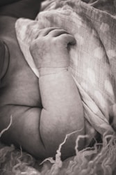 a baby wrapped up in a blanket on top of a bed