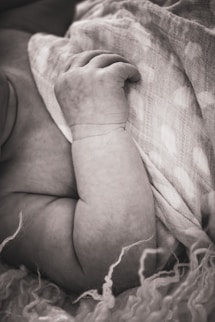 a baby wrapped up in a blanket on top of a bed