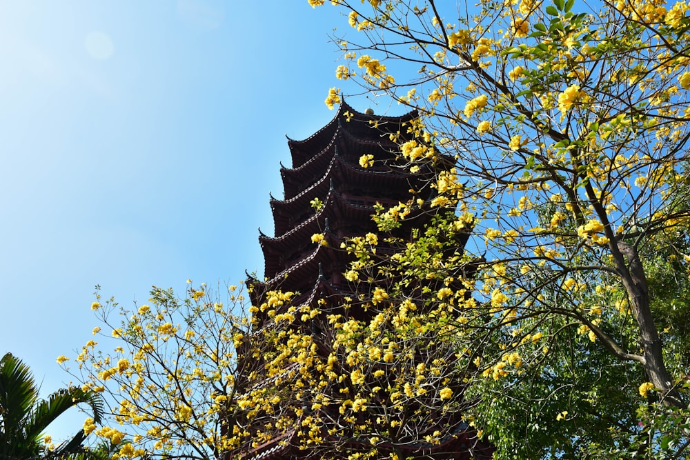 a tall tower with a bunch of yellow flowers on it