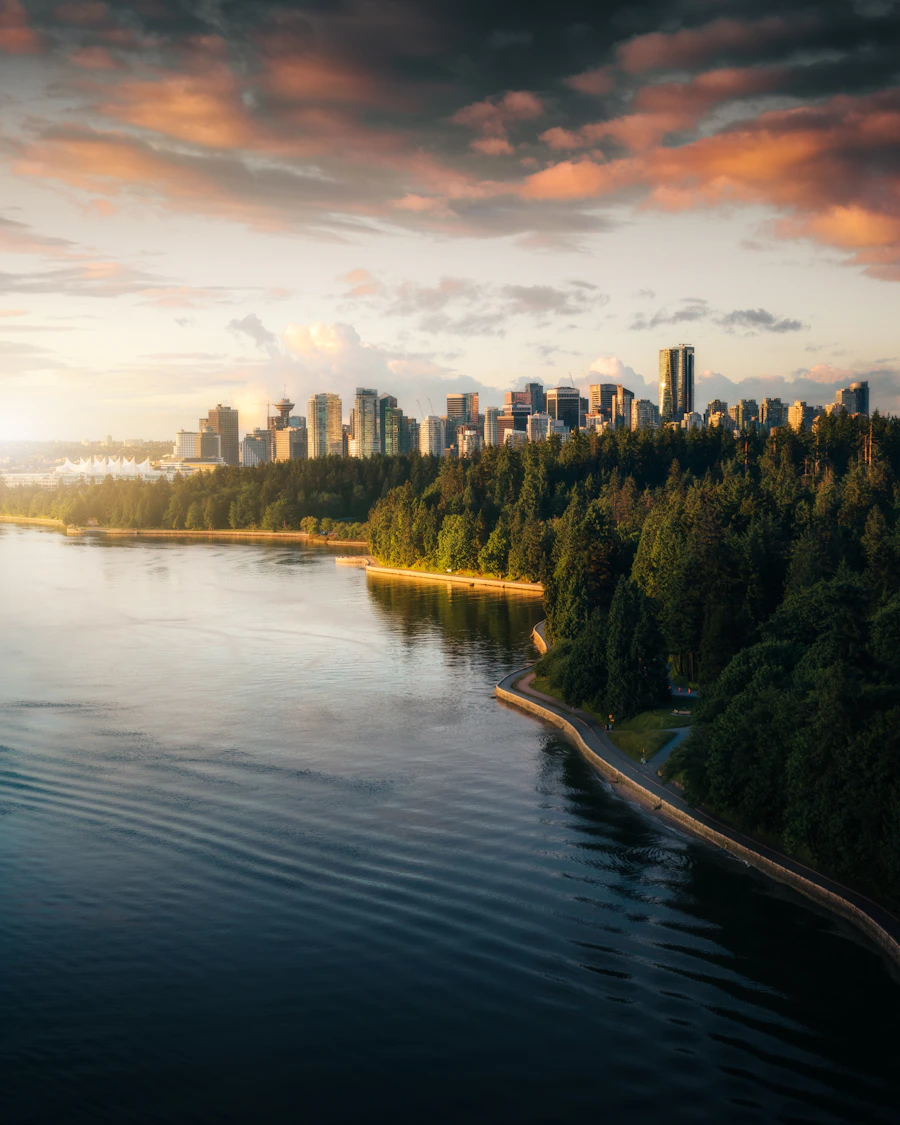 Vancouver seawall promenade at dusk with city lights beginning to glow and mountains still visible in the background