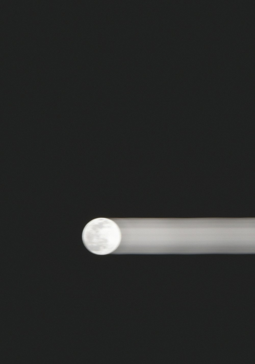 a close up of a white object on a black background