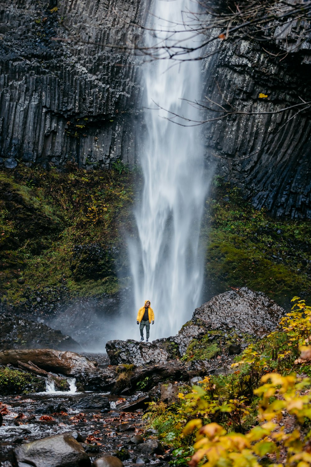 a man standing in front of a waterfall