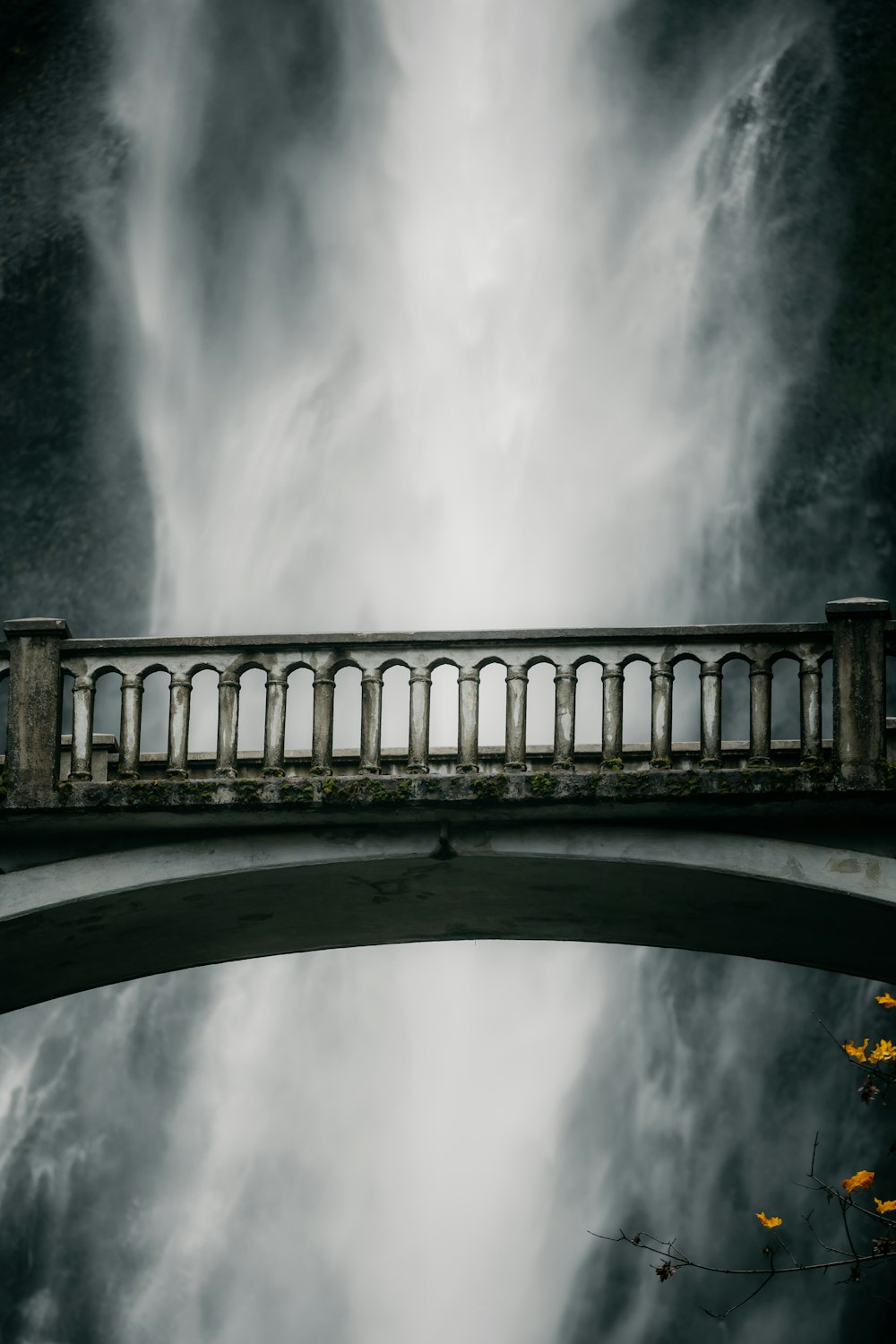 a bridge over a body of water under a cloudy sky