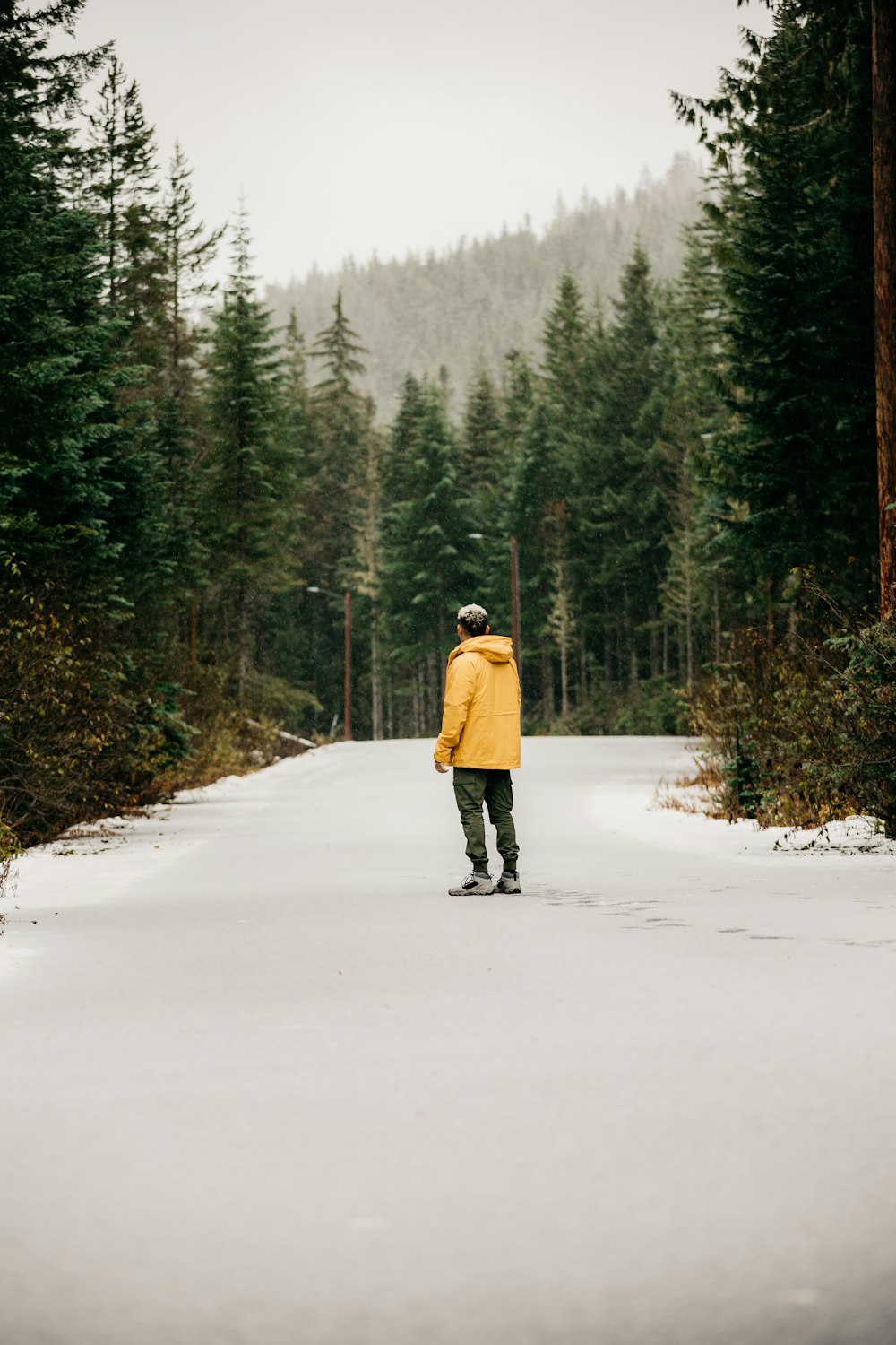 a man walking down a snow covered road