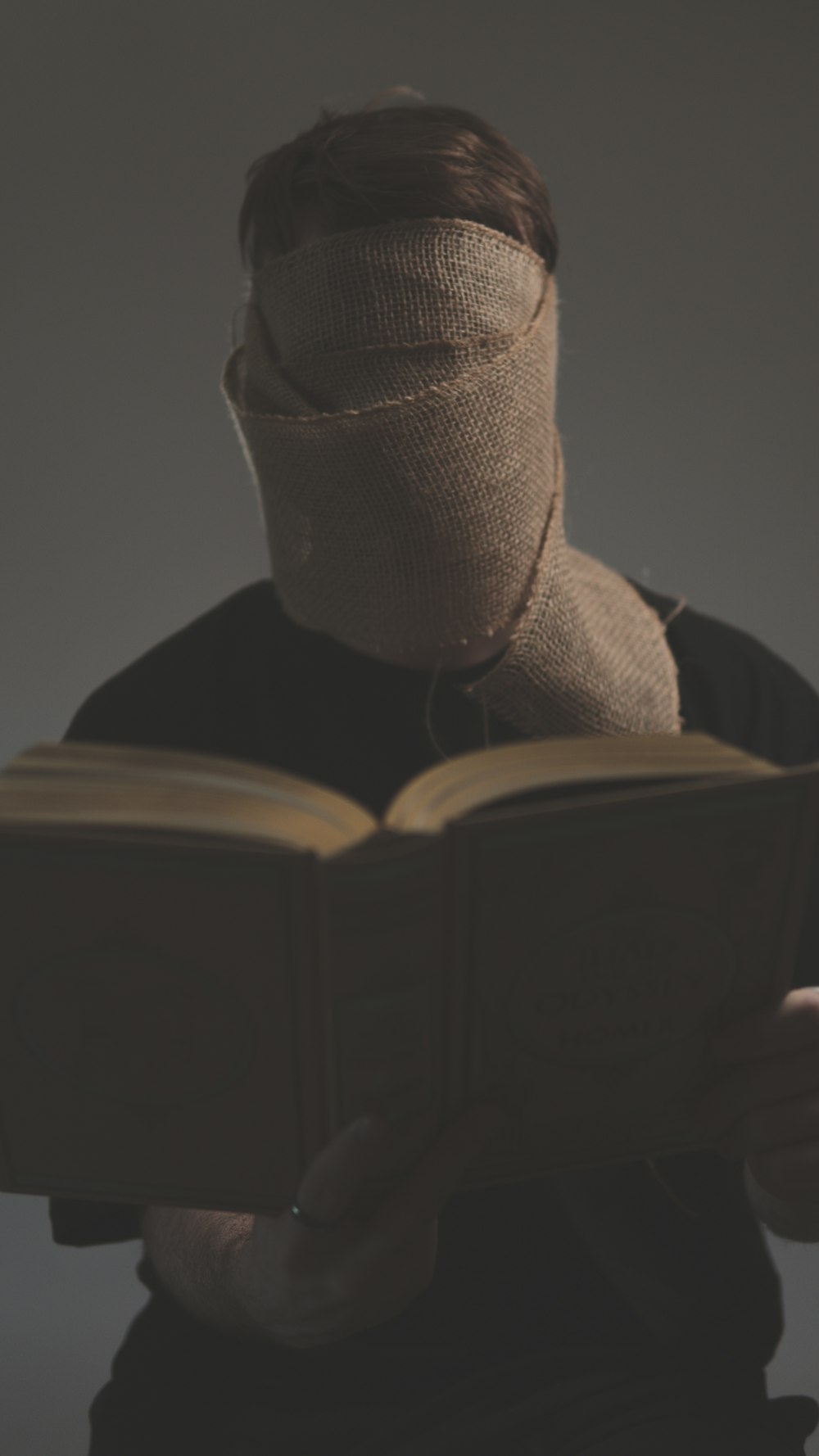 a man with a bandaged head reading a book