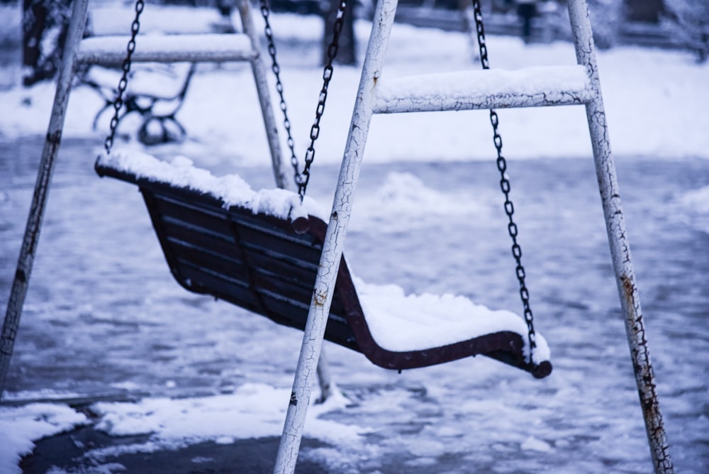 a swing that is covered in snow in a park