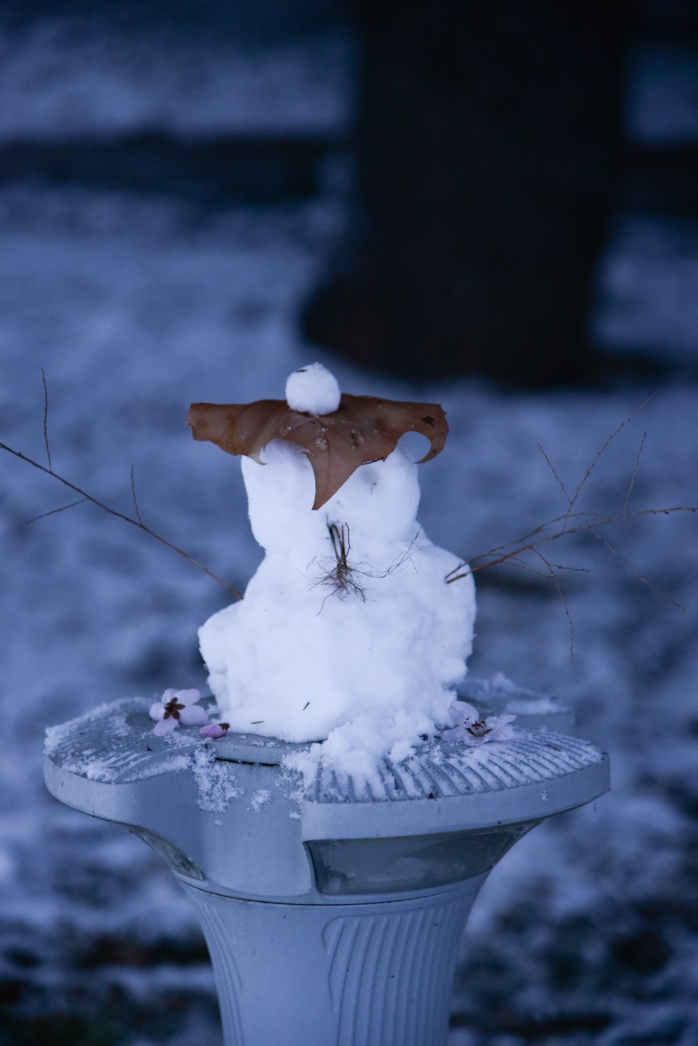 a snowman is sitting on top of a fire hydrant