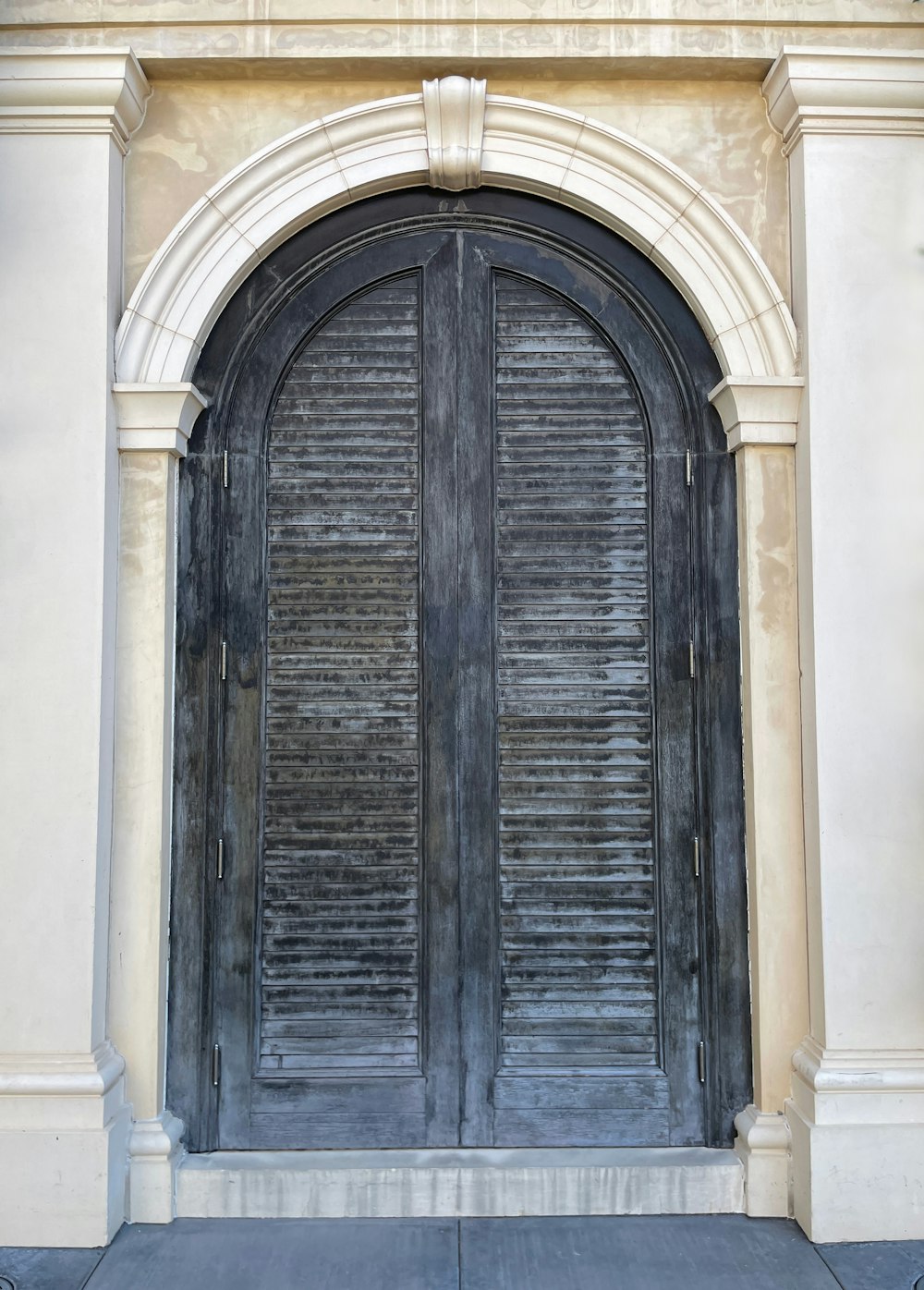 a large wooden door with a decorative arch above it
