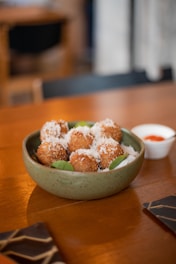 a bowl of food sitting on top of a wooden table