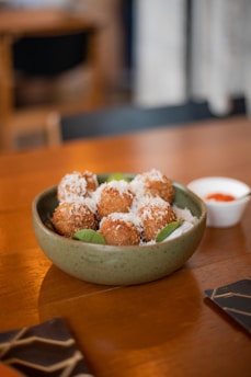 a bowl of food sitting on top of a wooden table