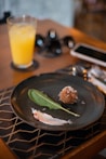 a plate of food on a table with a glass of orange juice
