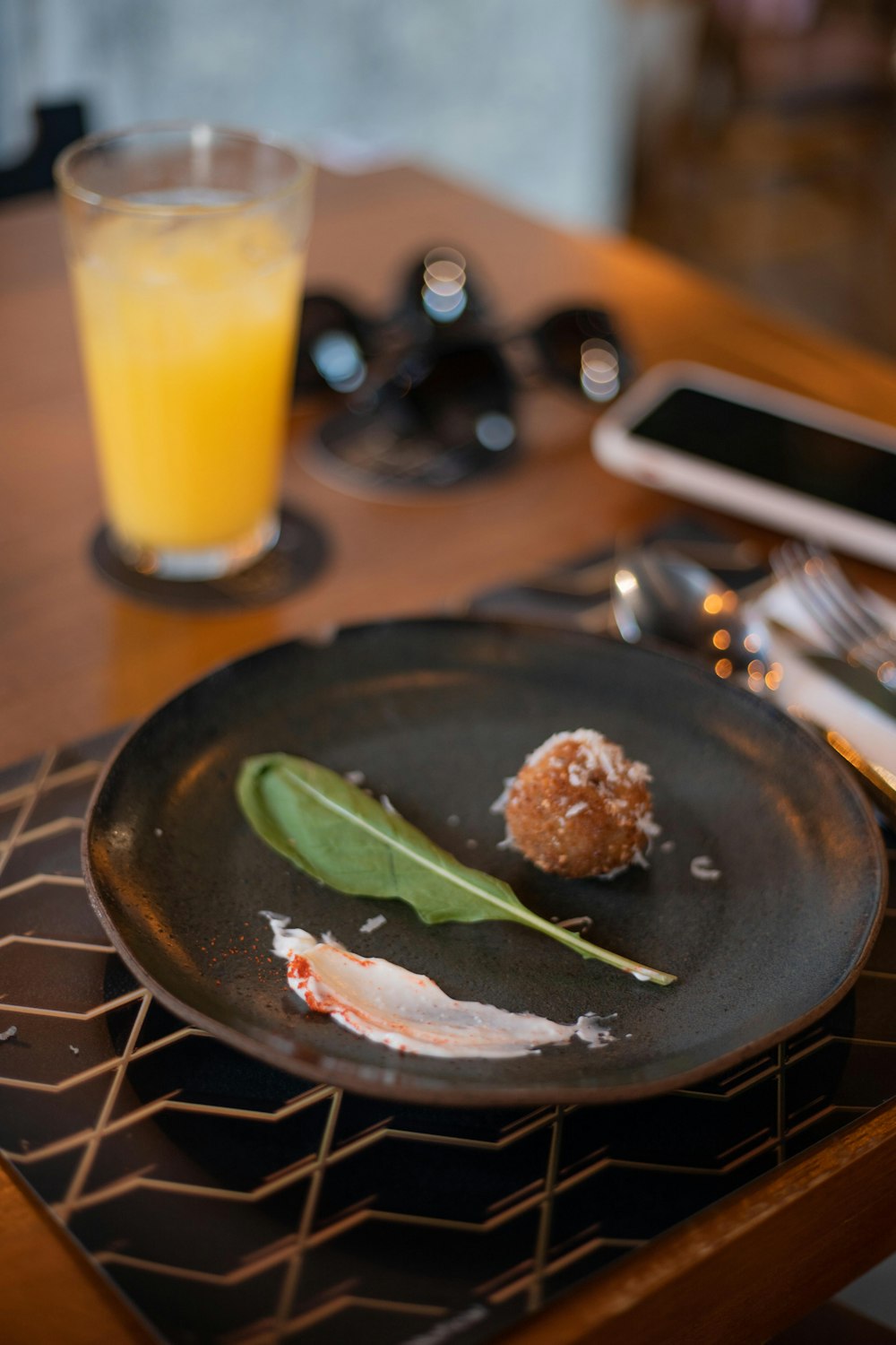 a plate of food on a table with a glass of orange juice