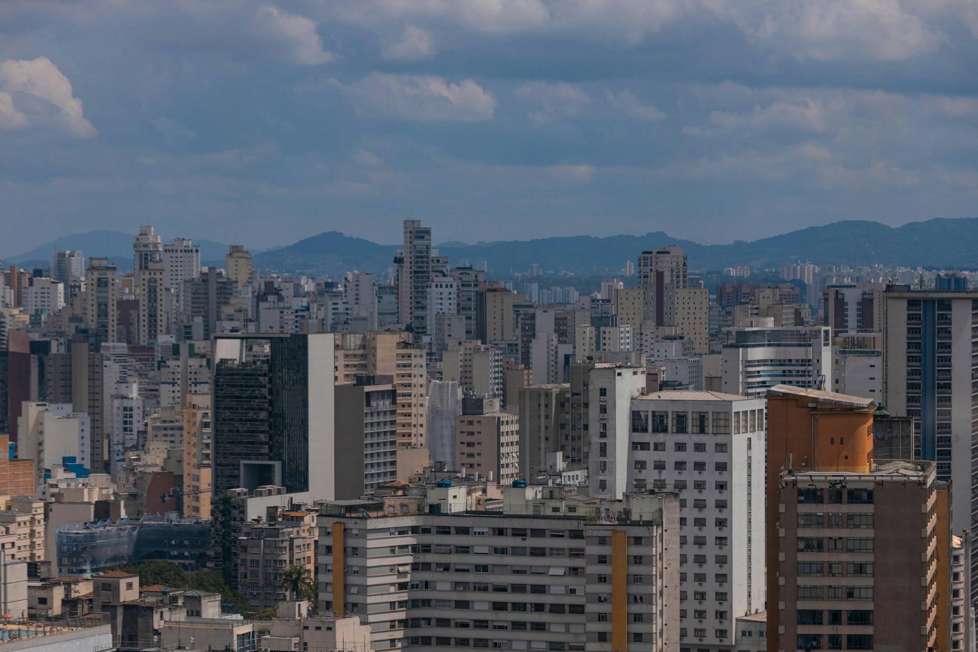 a city skyline with tall buildings and mountains in the background