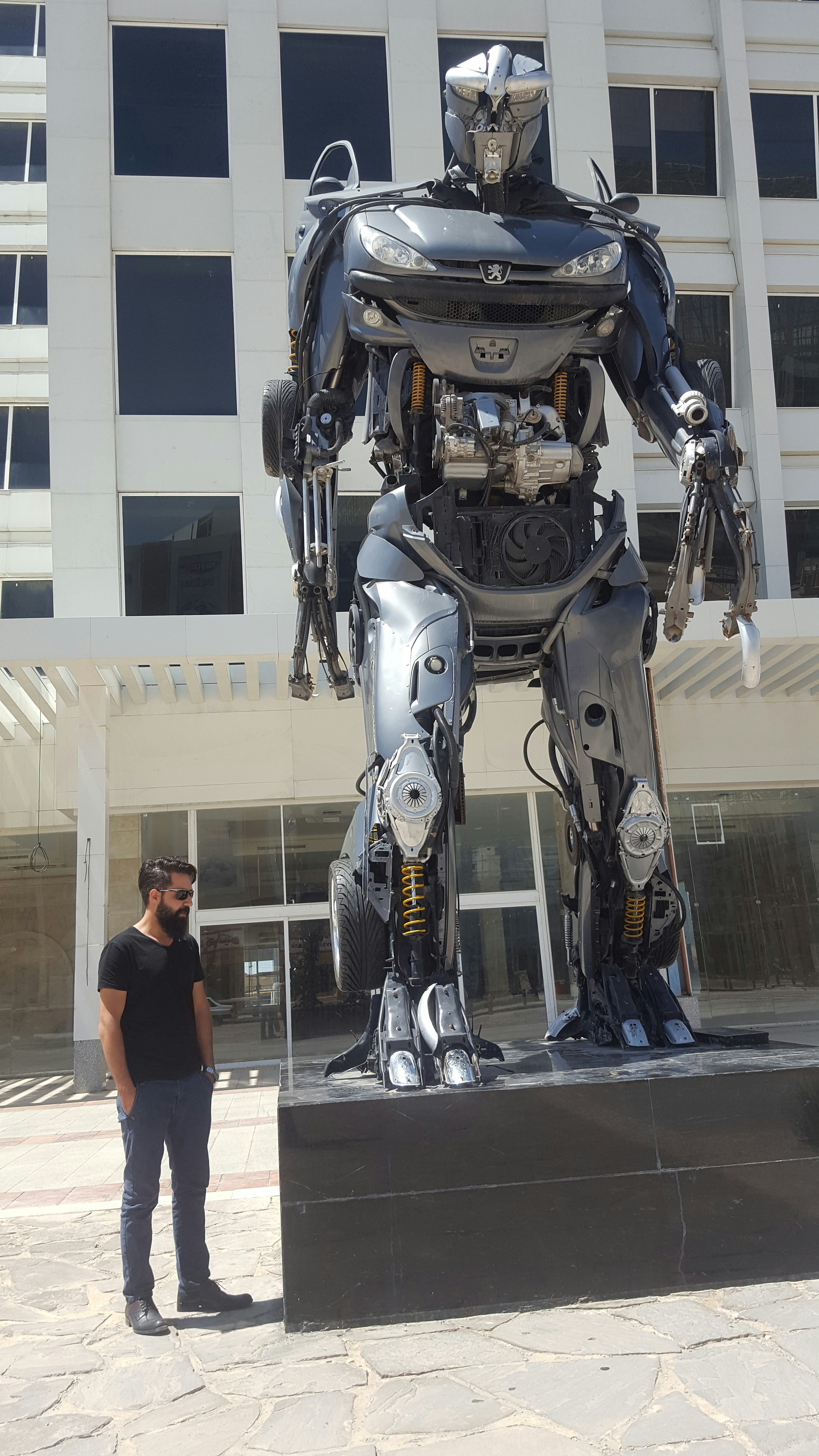 a man standing next to a giant robot statue