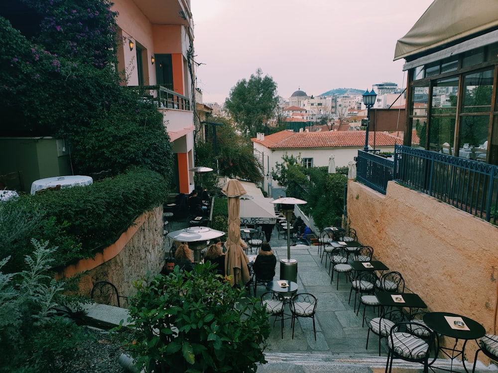 un patio al aire libre con mesas, sillas y sombrillas