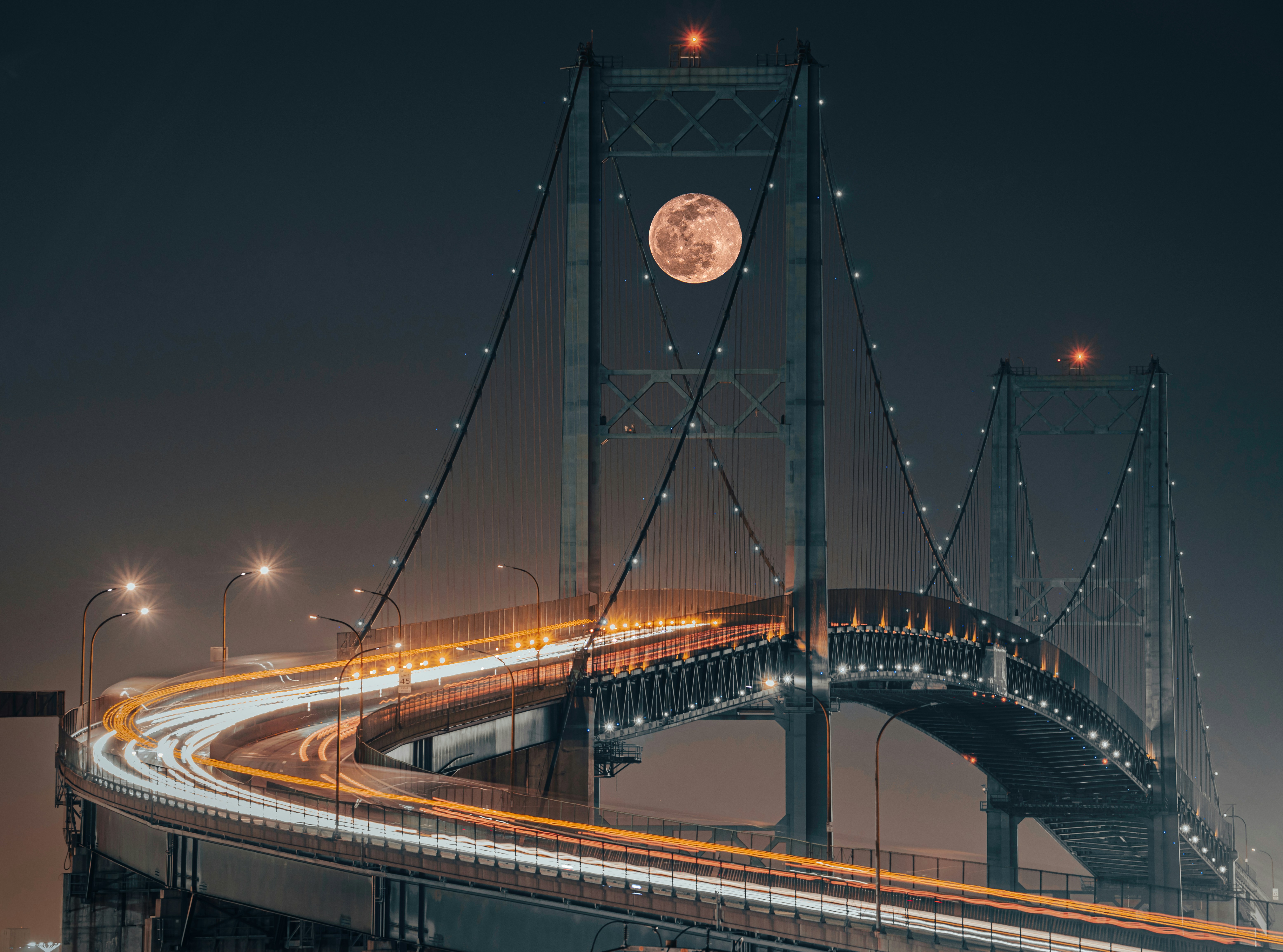 a bridge with a full moon in the background