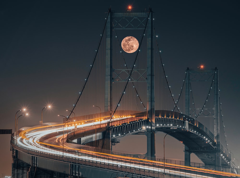 Un puente con luna llena al fondo