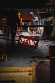 a red off limit sign hanging from a rope