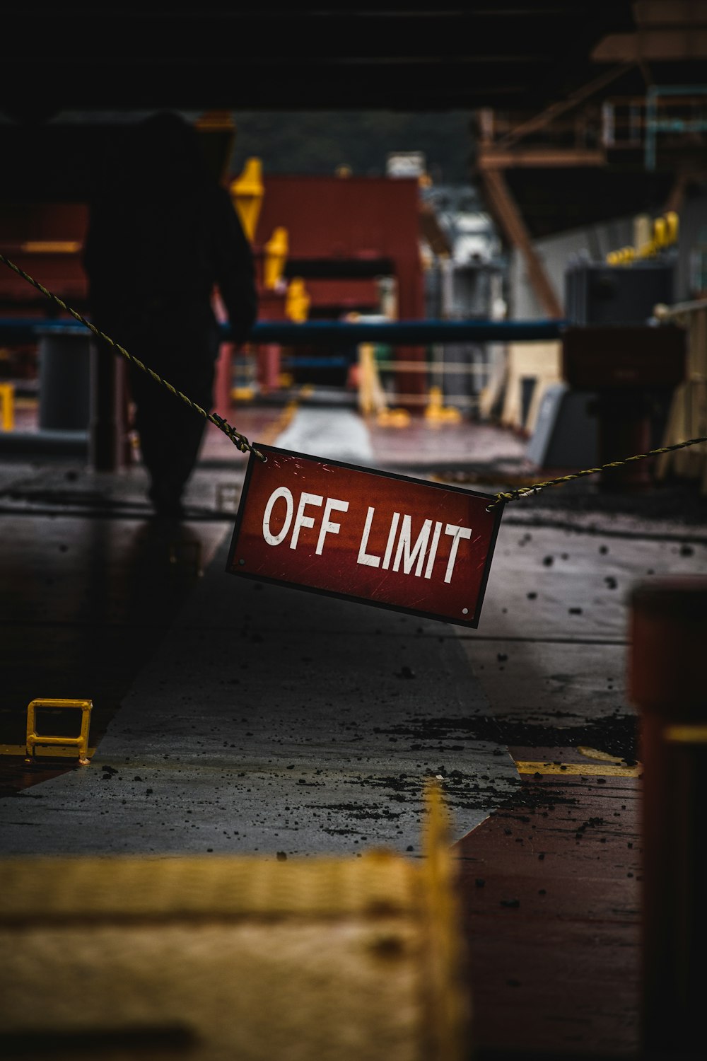 a red off limit sign hanging from a rope