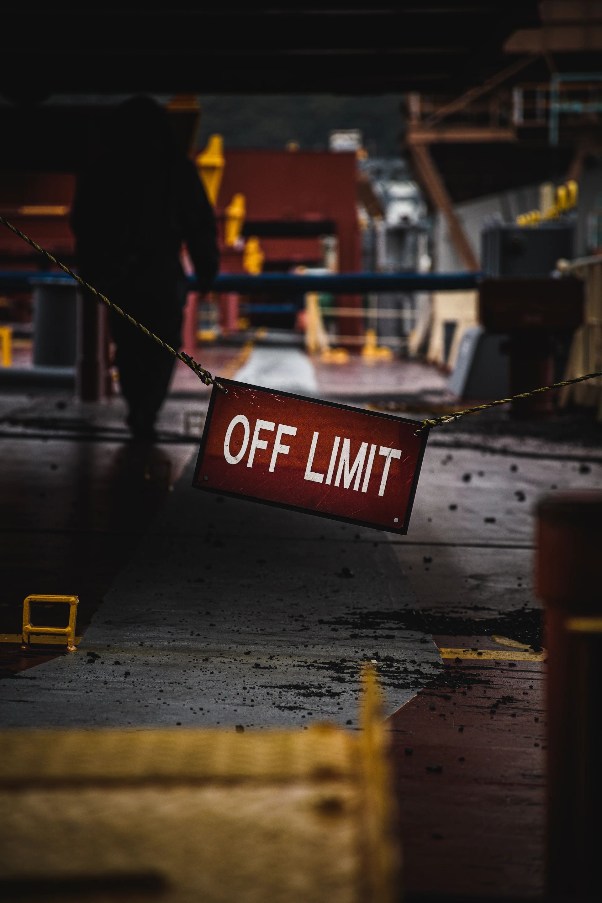 a red off limit sign hanging from a rope