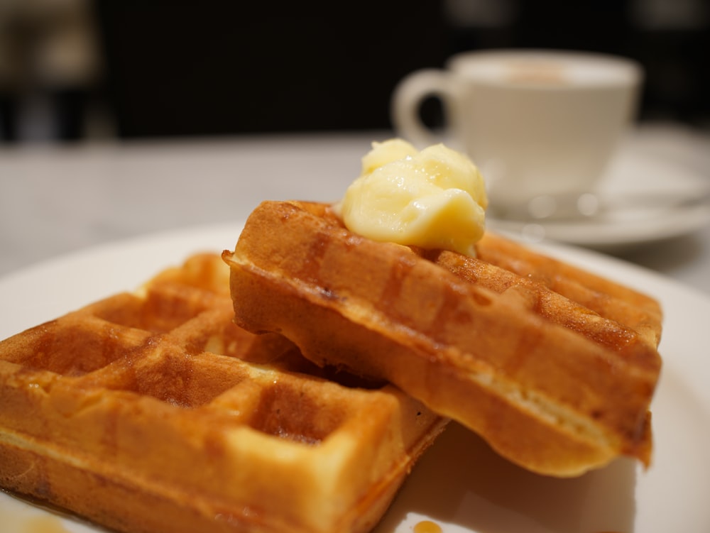 a white plate topped with two waffles covered in butter