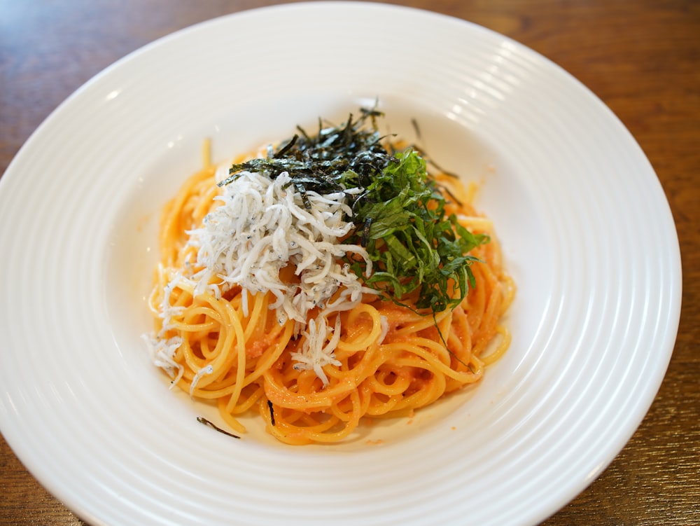 a white plate topped with pasta and cheese