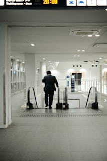 a man in a suit walking down an escalator