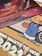 The image features a collection of promotional materials. At the top, there is a Coca-Cola Creations Stardust Limited Edition display with a red outer space theme, including celestial bodies and what appears to be a rocky planetary surface. Below it, there is a colorful cartoon character in blue overalls holding a clock, with part of a car wheel visible in the background. There is also a bold text message suggesting participation in an event or contest with large numbers '2021'.