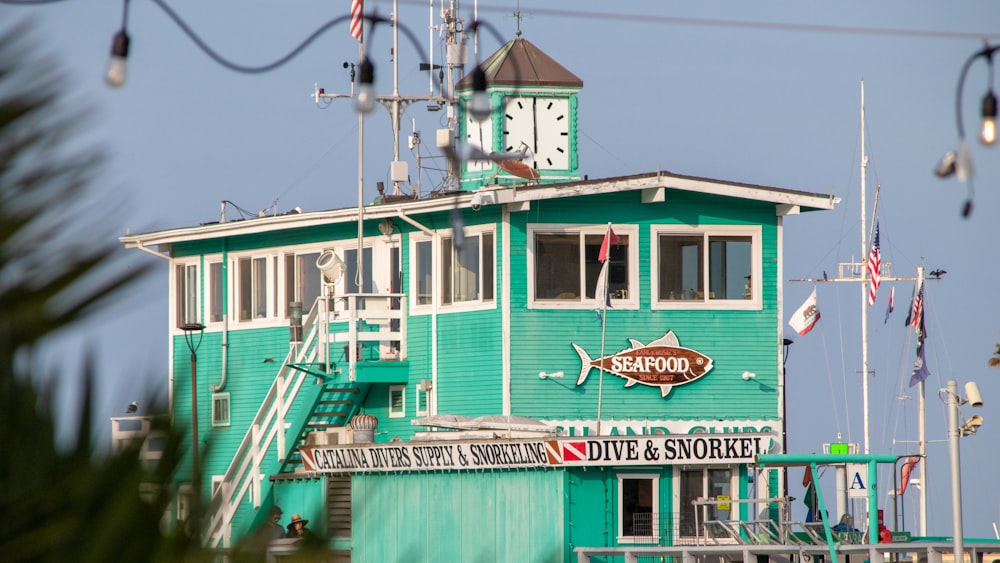 a green building with a clock on the top of it