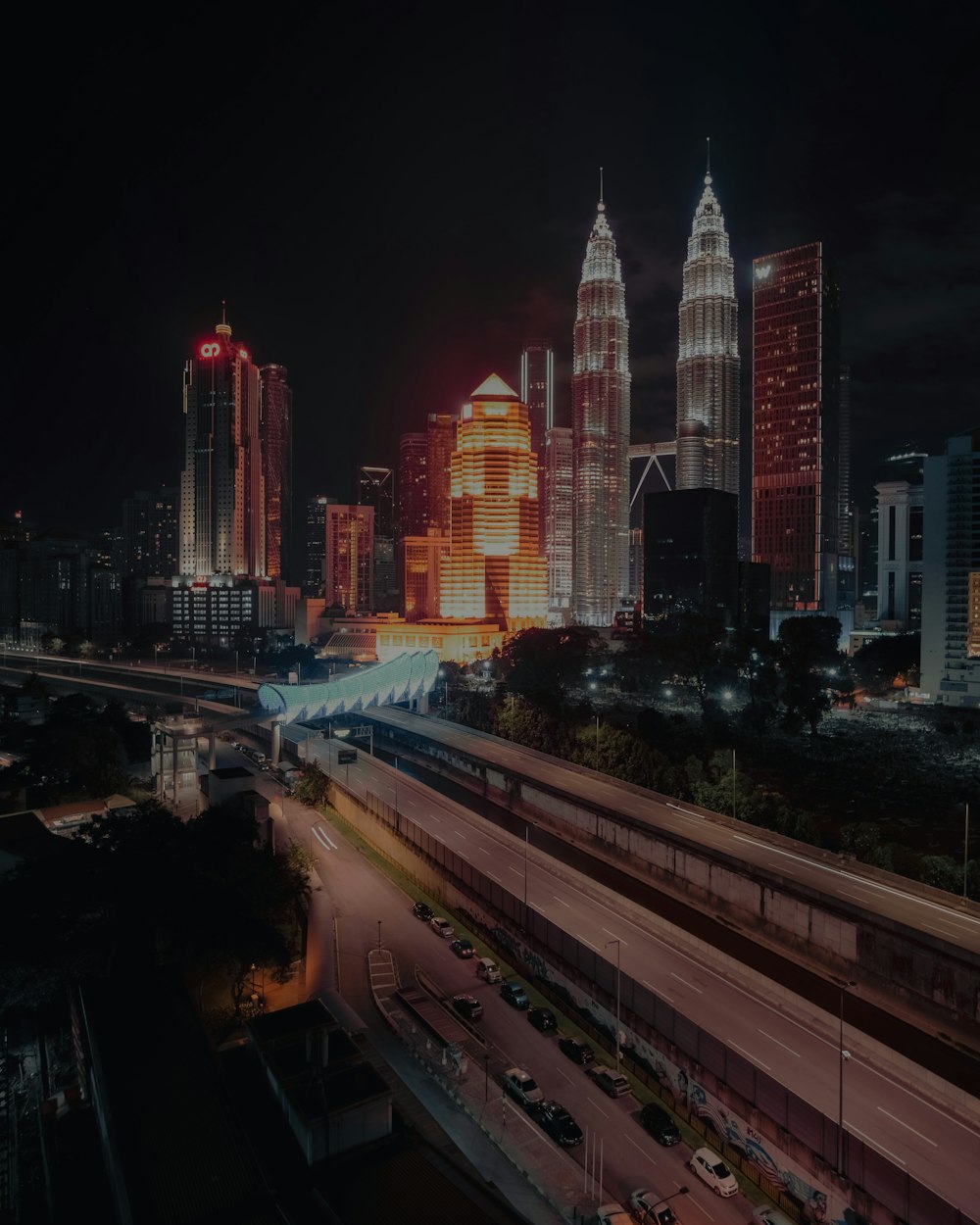 a city skyline at night with a train on the tracks