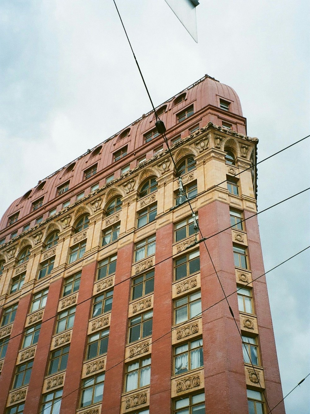 a tall red brick building with a clock on it's side