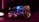 A small truck is driving on a road at night, featuring bright signage on its side advertising a restaurant and catering service. The vehicle is illuminated by purple and blue lights, creating a striking contrast with the dark surroundings.