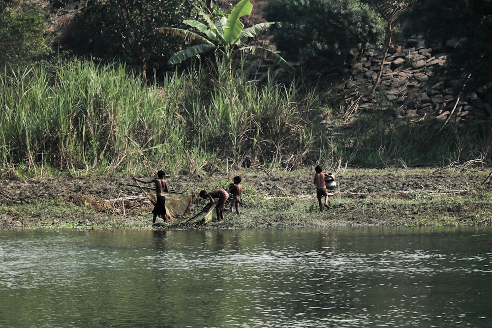 a group of people standing next to a body of water