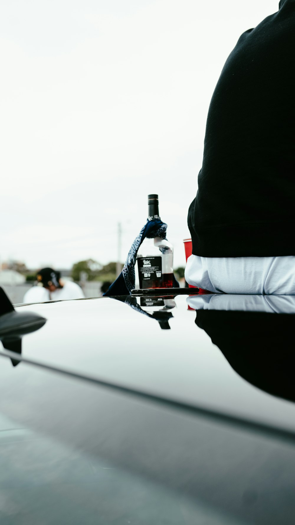 une bouteille d’alcool sur le capot d’une voiture