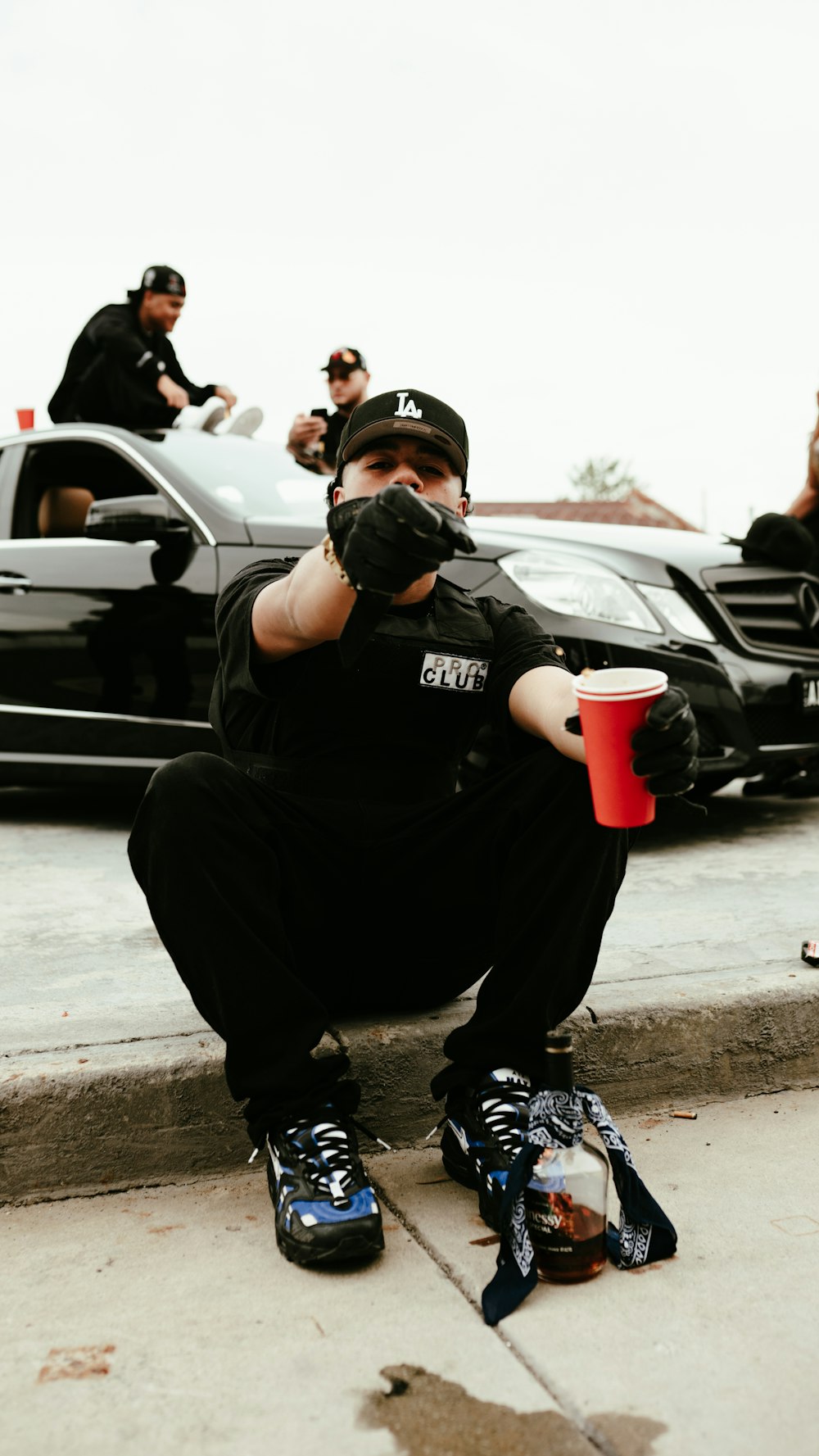 a man sitting on a curb with a cup of coffee