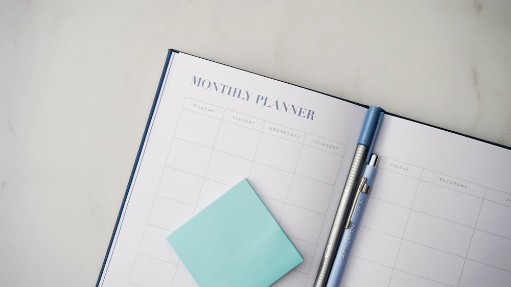 a planner with a pen on top of it