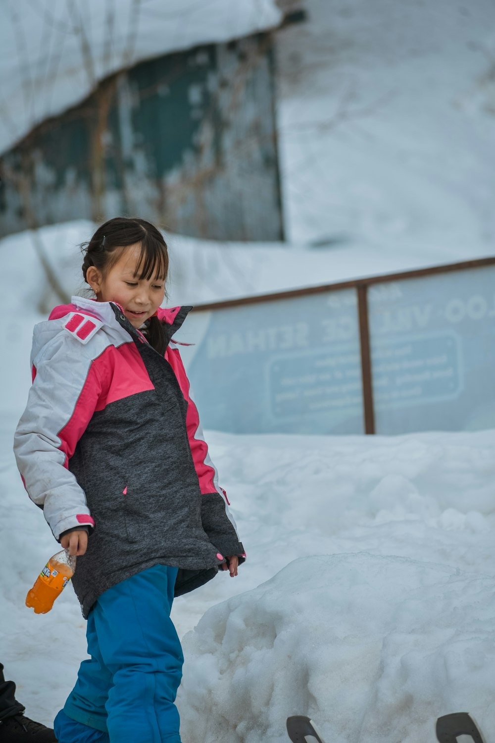 a little girl standing on a snowboard in the snow