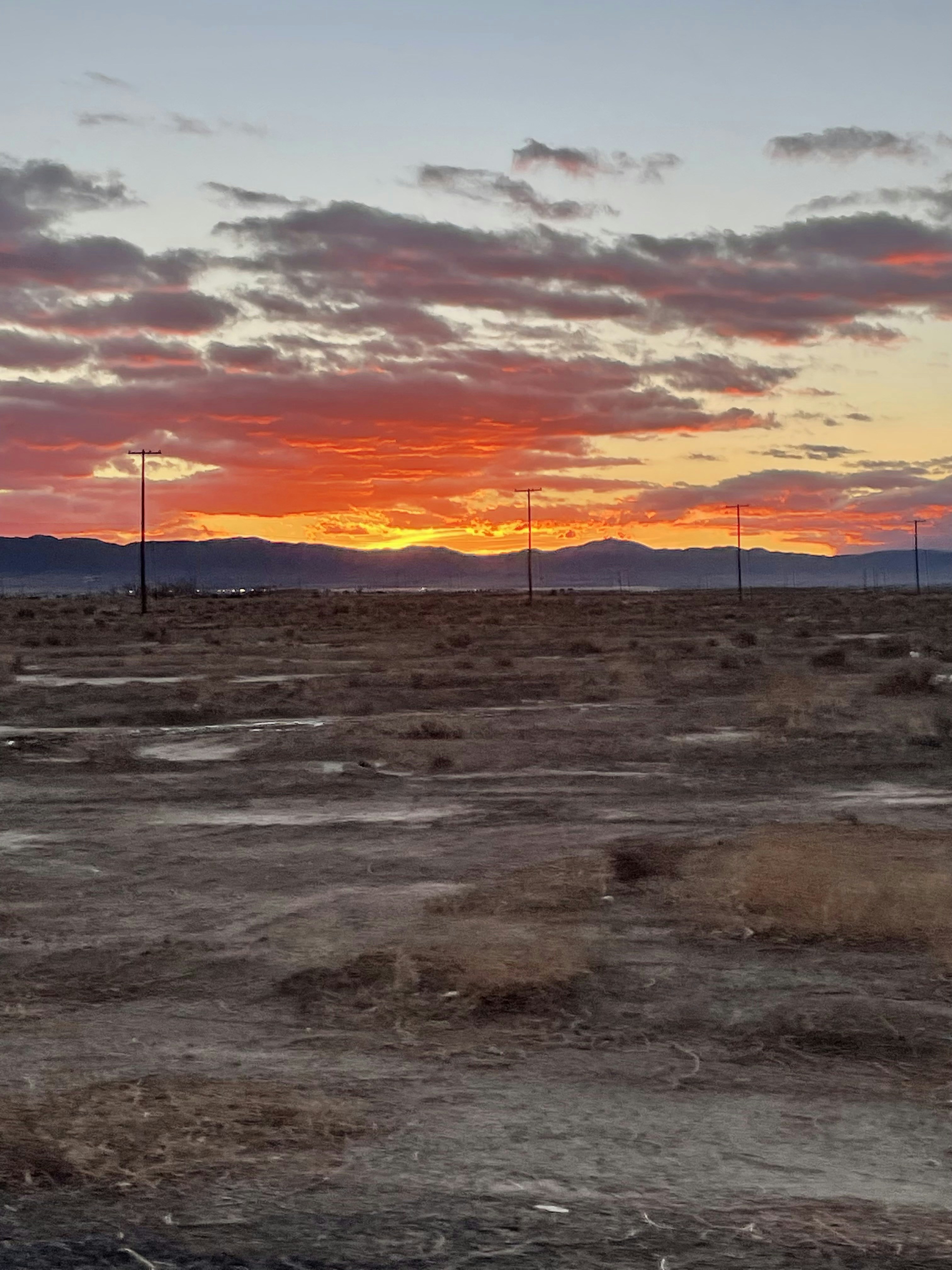 The sun is setting in the distance over the desert photo – Free ...