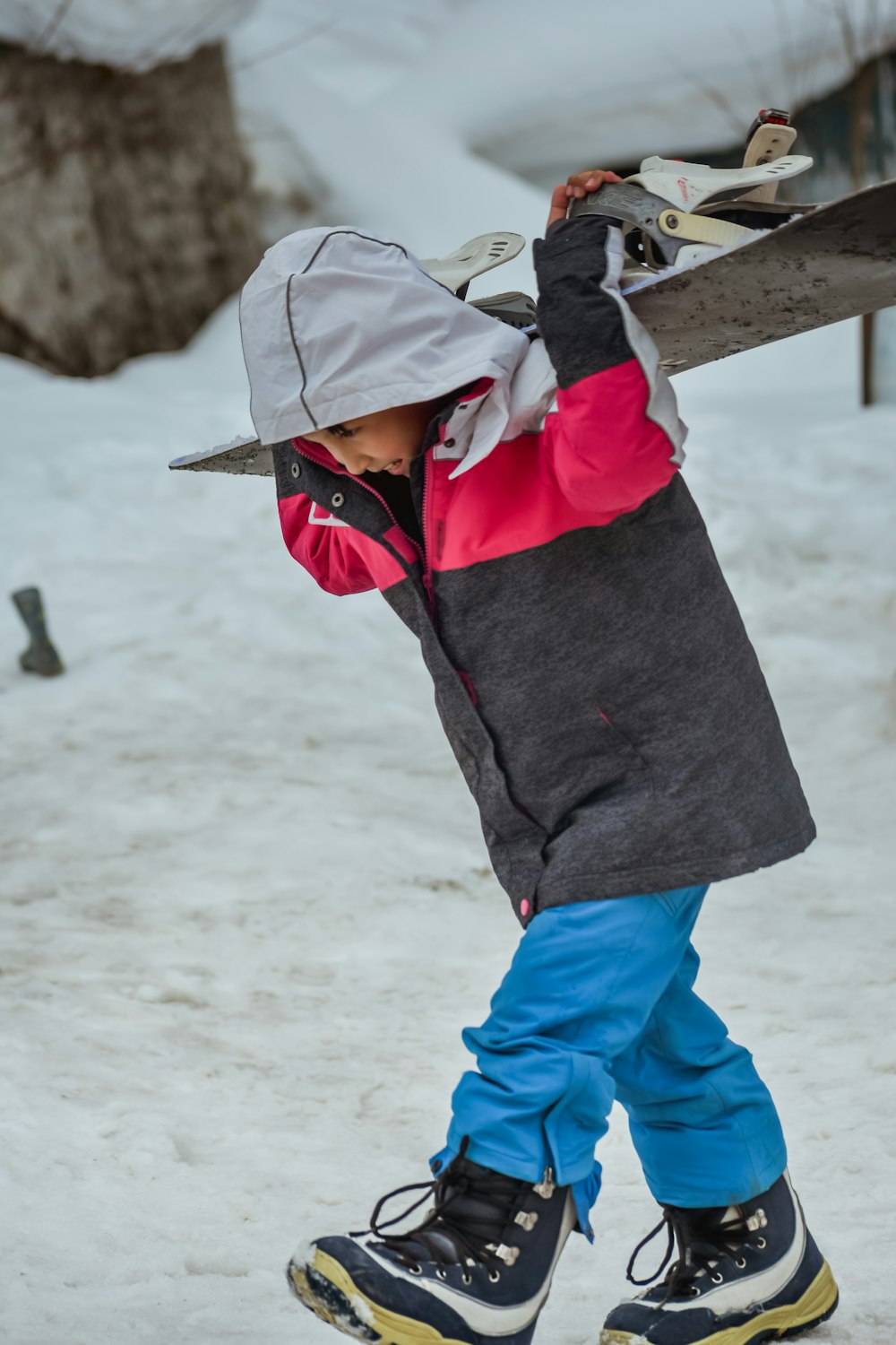 a young child holding a snowboard on top of a snow covered ground