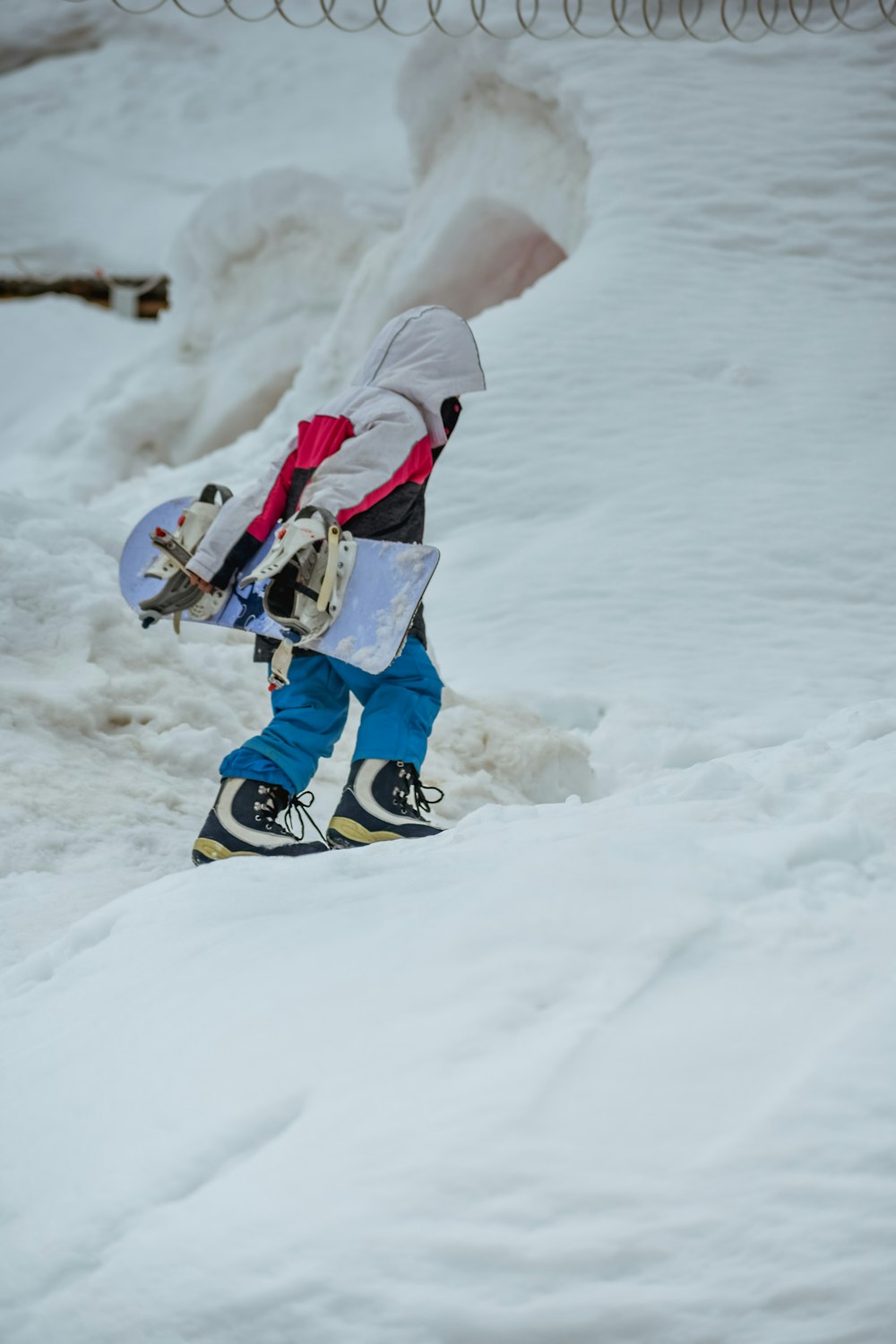 a person walking in the snow with a snowboard