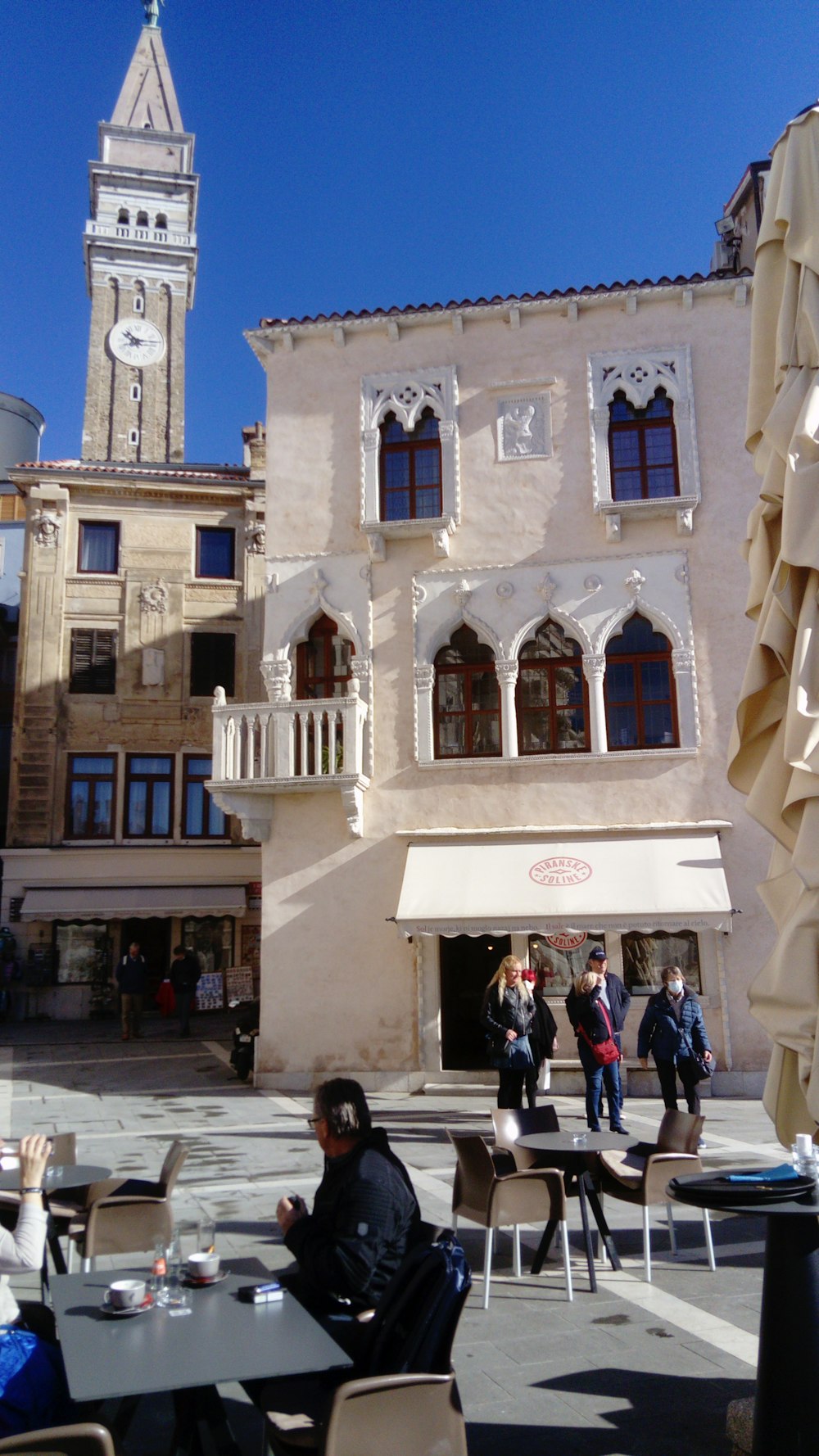 a group of people sitting at tables in front of a building