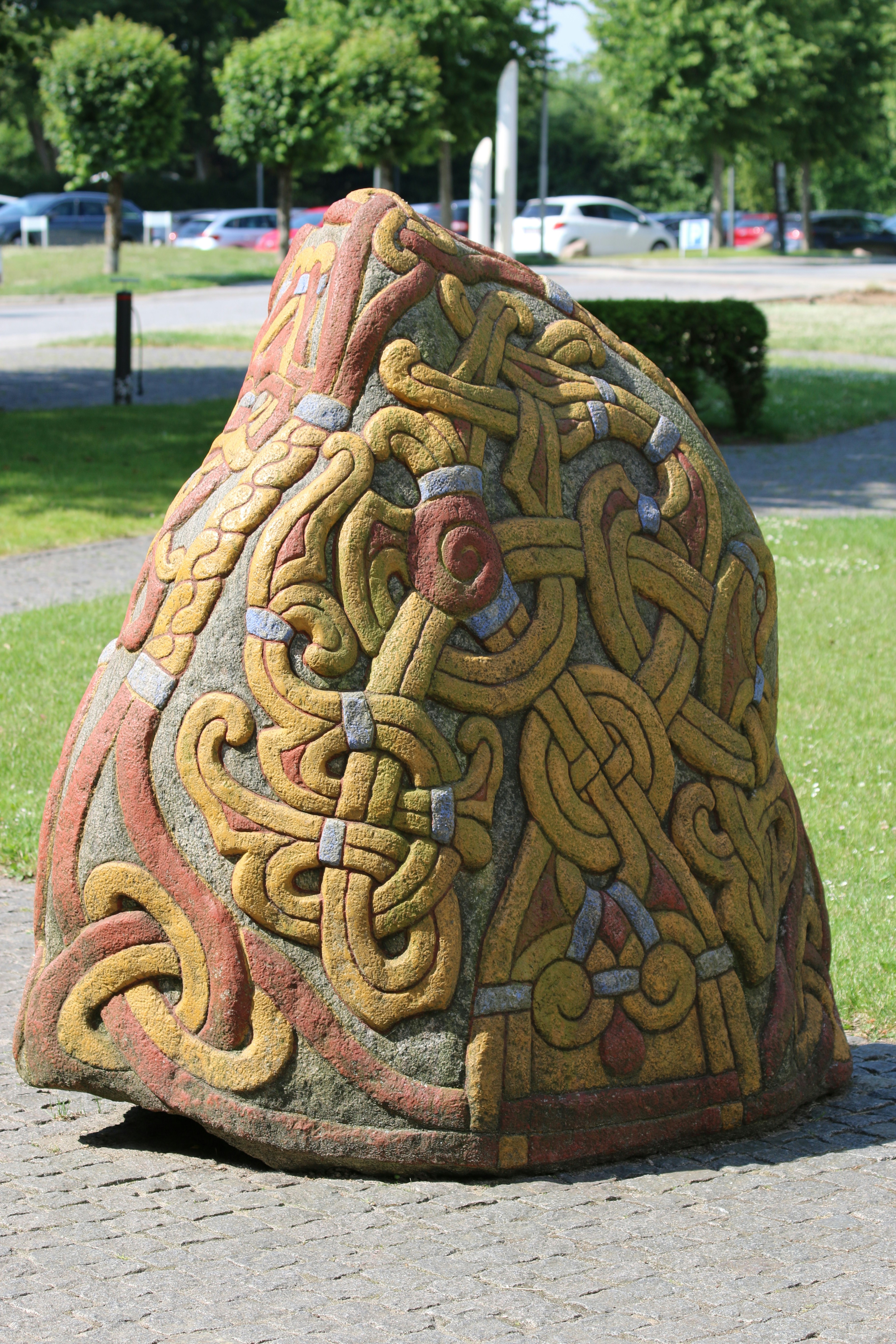 a rock with a design on it sitting on a sidewalk