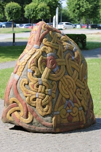 a rock with a design on it sitting on a sidewalk