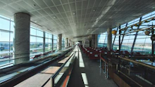Long airport concourse lined with tall windows